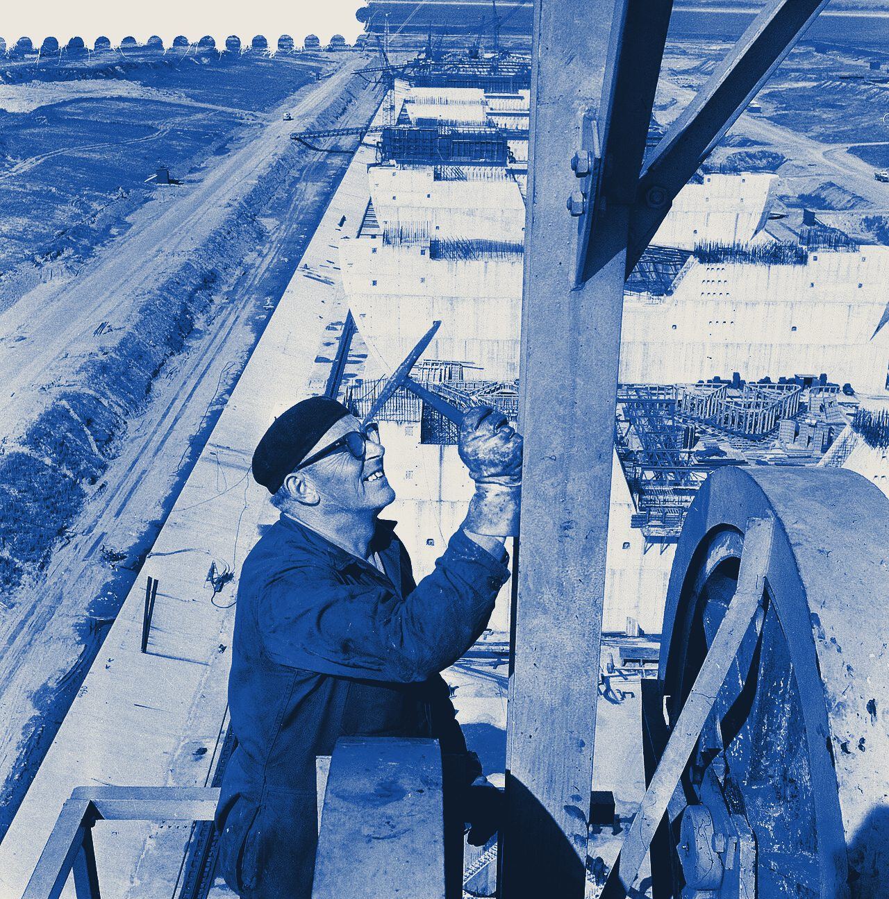 Een arbeider hoog op de brugkraan bij de bouw van de Haringvlietsluizen